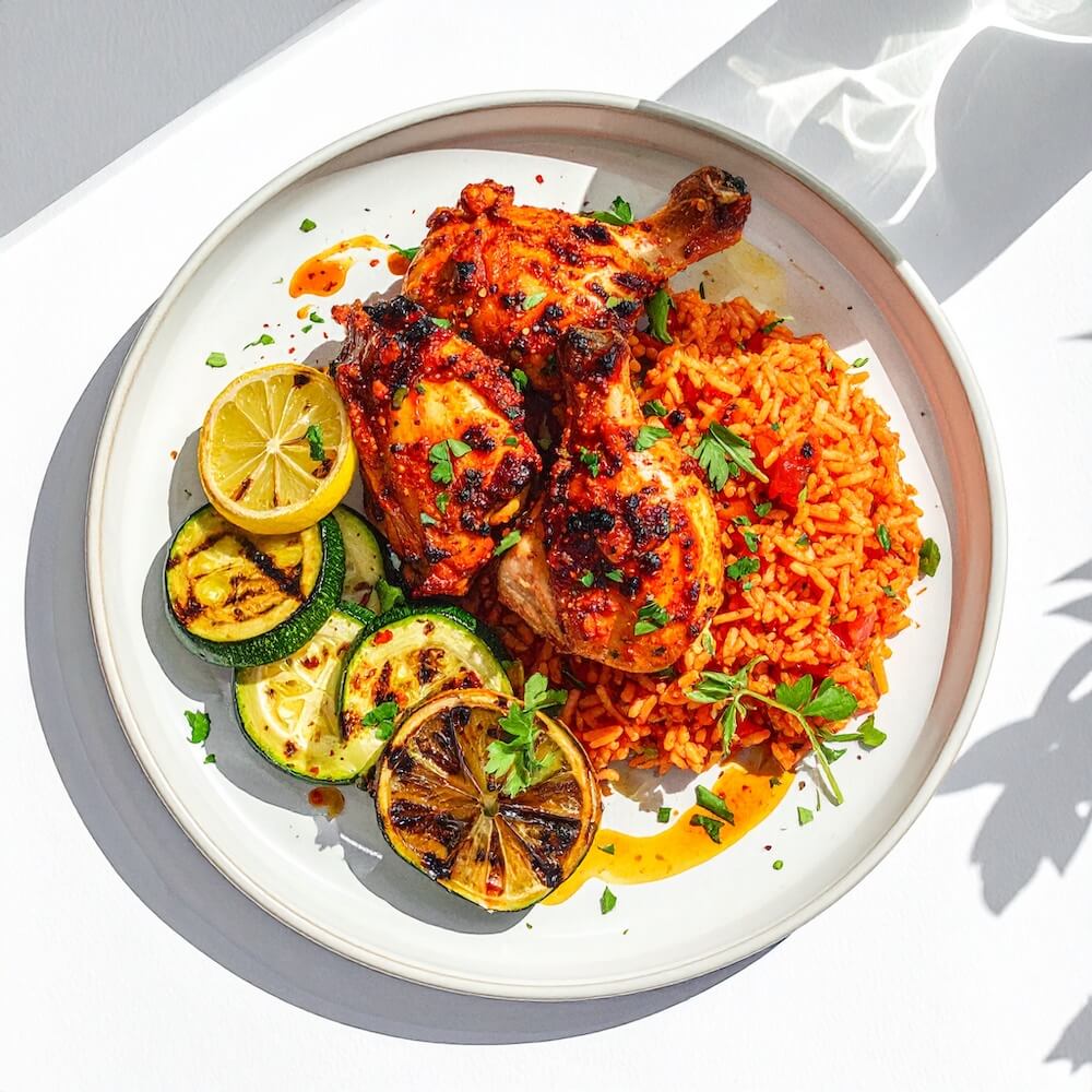 Piri piri chicken thigh with tomato rice, grilled courgette and charred lemon (gf)