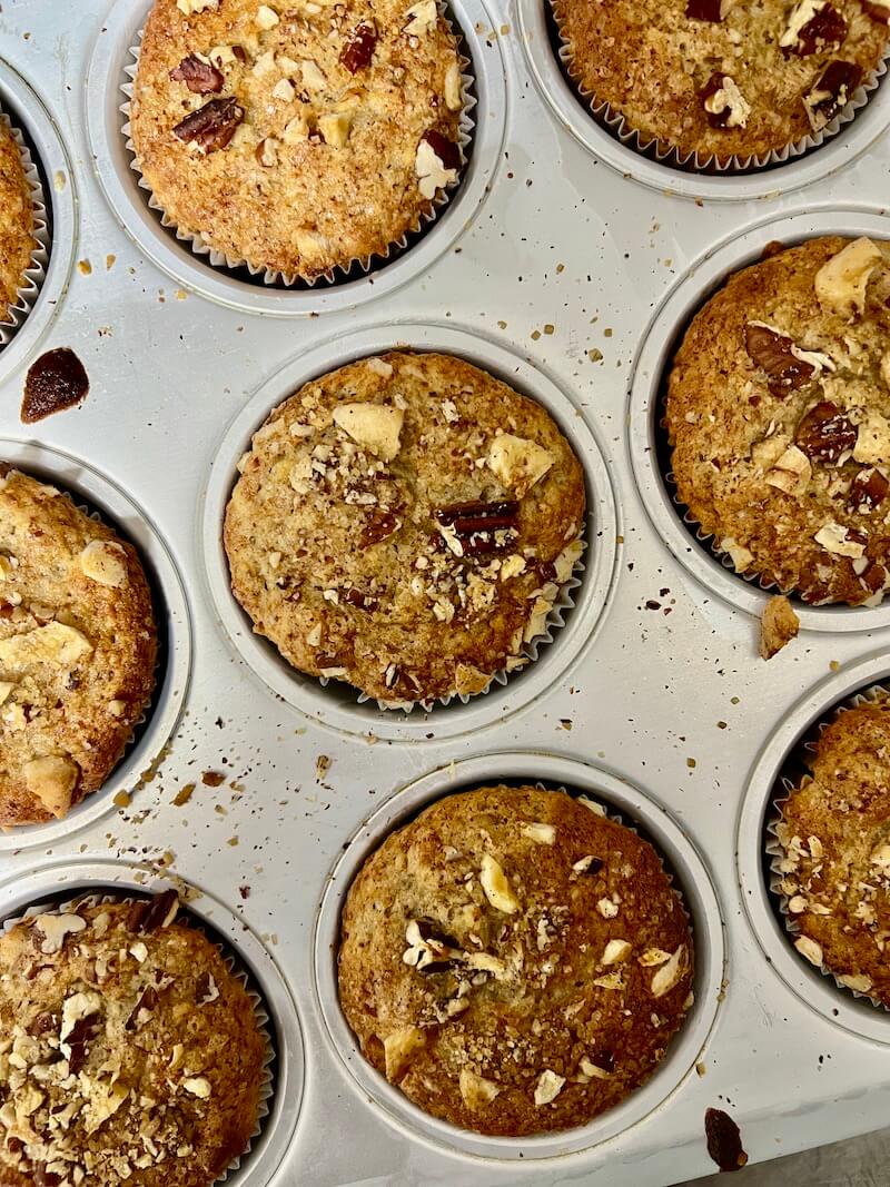 Photograph from above of blueberry and oat muffins still in the muffin tray straight from the oven